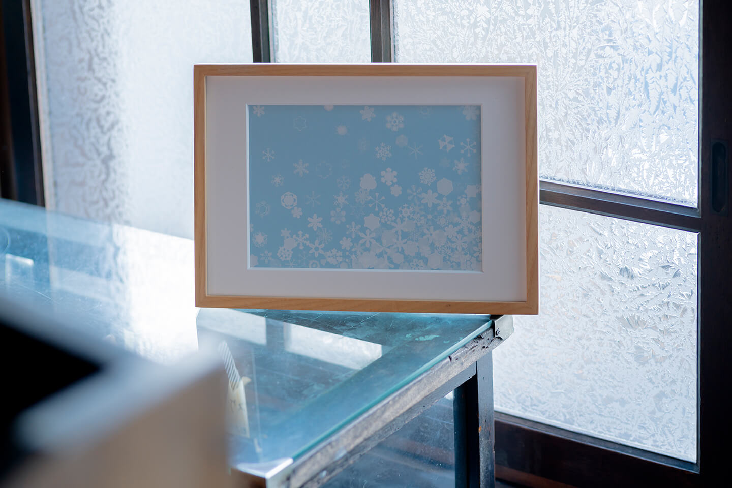 「小雪」芳木 麻里絵　シルクスクリーン<br/>
200年ほど前、江戸時代のお殿様が雪の結晶を観察してまとめた『雪華図説』をもとに制作しました。<br/>これから迎える冬を想像して澄んだ青い空に小さな雪を散らしました。